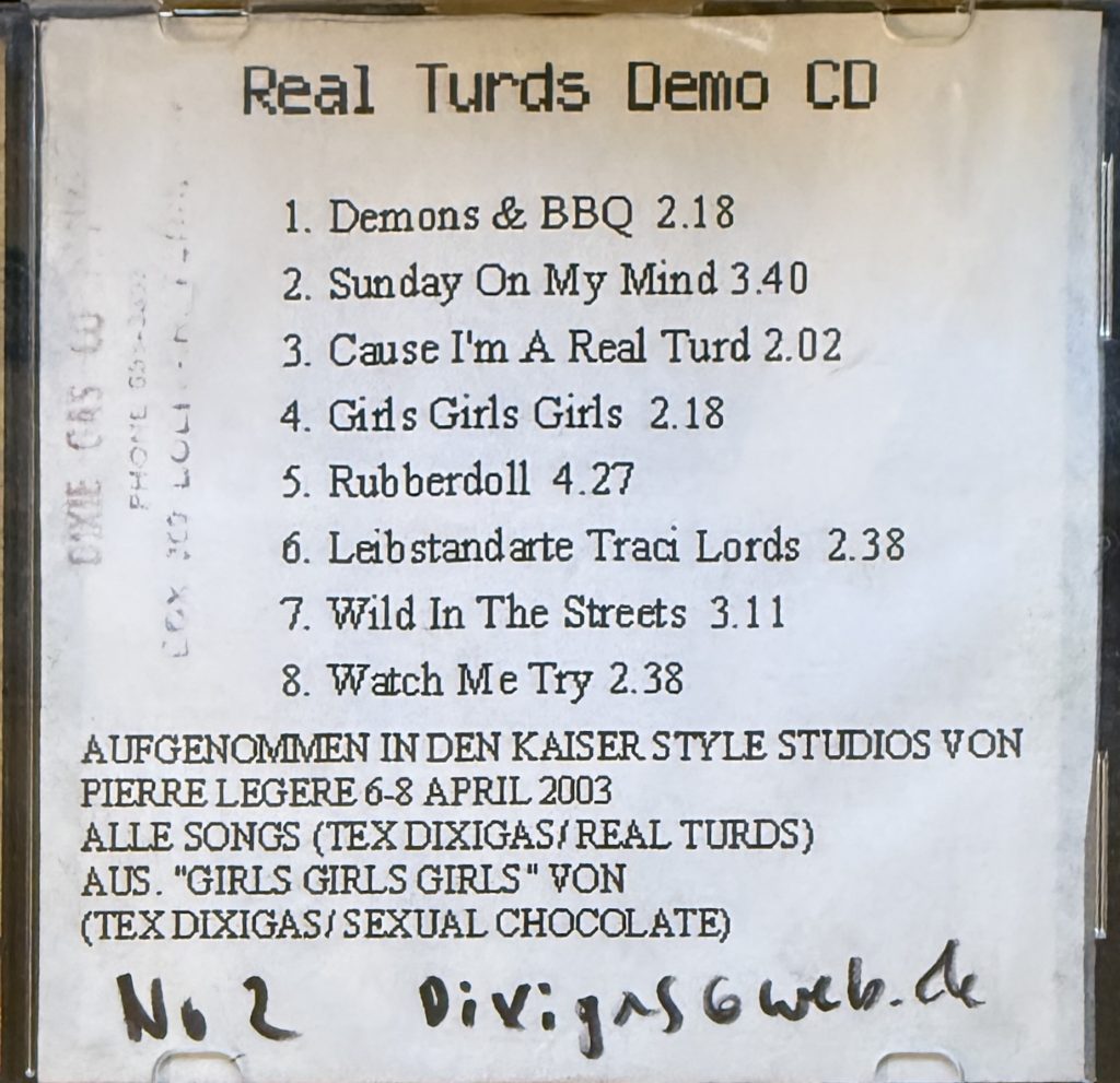 Real Turds Demo CD. 1. Demons and BBQ 2. Sunday on my mind 3. Cause I'm a real Turd 4. Girls Girls Girls  5. Rubberdoll 6. Leibstandarte Traci Lords  7. Wild in the Streets 8. Watch me try (Aufgenommen in den Kaiser Style Studios von Pierre Legere 6-8 April 2003 (Alle Songs von Tex Dixigas/ Real Turds . Außer " Girls Girls Girls" von Tex Dixigas/Sexual Chocolate)